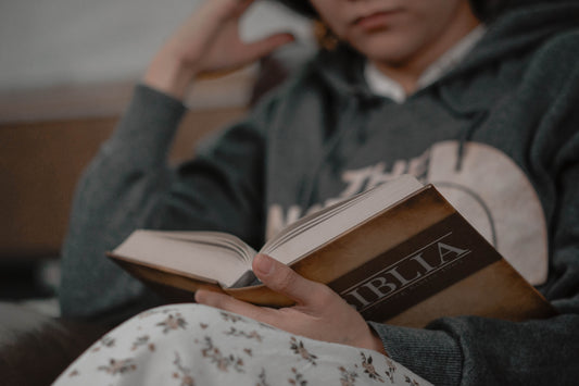 a person sitting on a couch reading a book