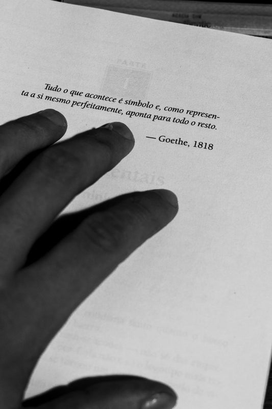 Hand on a book page with text